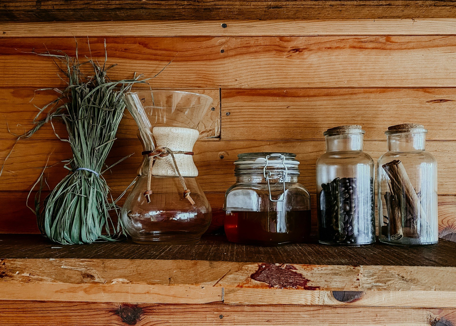 Herbs, oils, and natural remedy ingredients displayed on wooden shelf