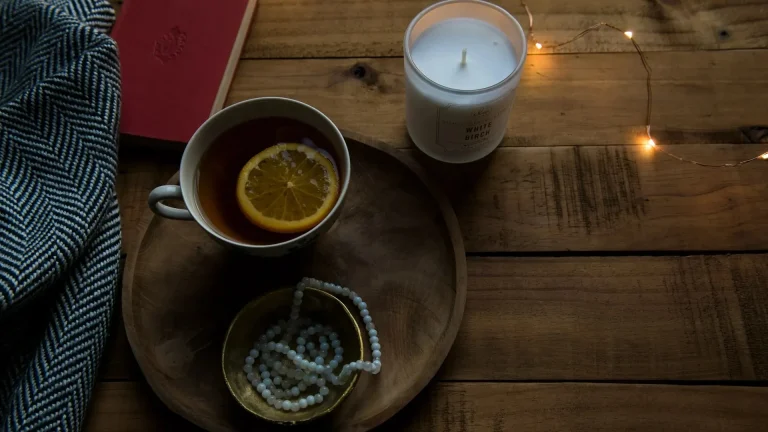 Burnout & nutrition still life with lemon tea, candle, and cozy textures—symbolizing nutrition, rest, and stress-relief for mental exhaustion.
